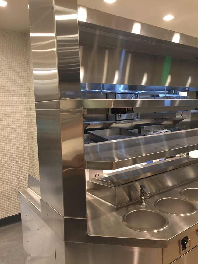 Utility chase at end of stainless steel chefs counter