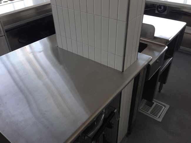 Stainless steel center island welded in place around building column